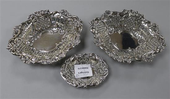 A pair of Edwardian pierced repousse silver sweetmeat dishes, Birmingham, 1905 and a smaller silver dish, largest 19.1 cm.